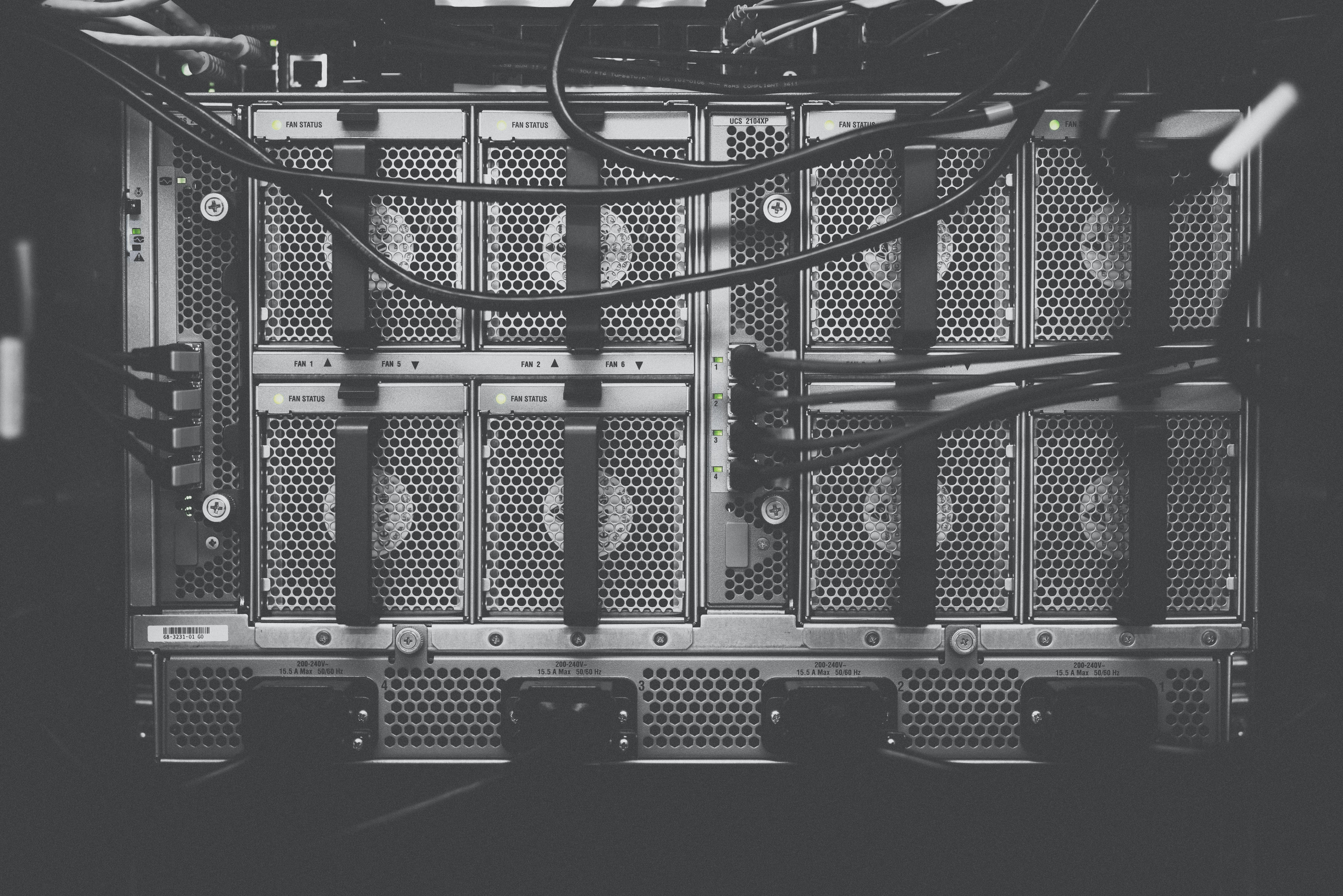 Un server rack in bianco e nero con cavi e indicatori di stato visibili.
